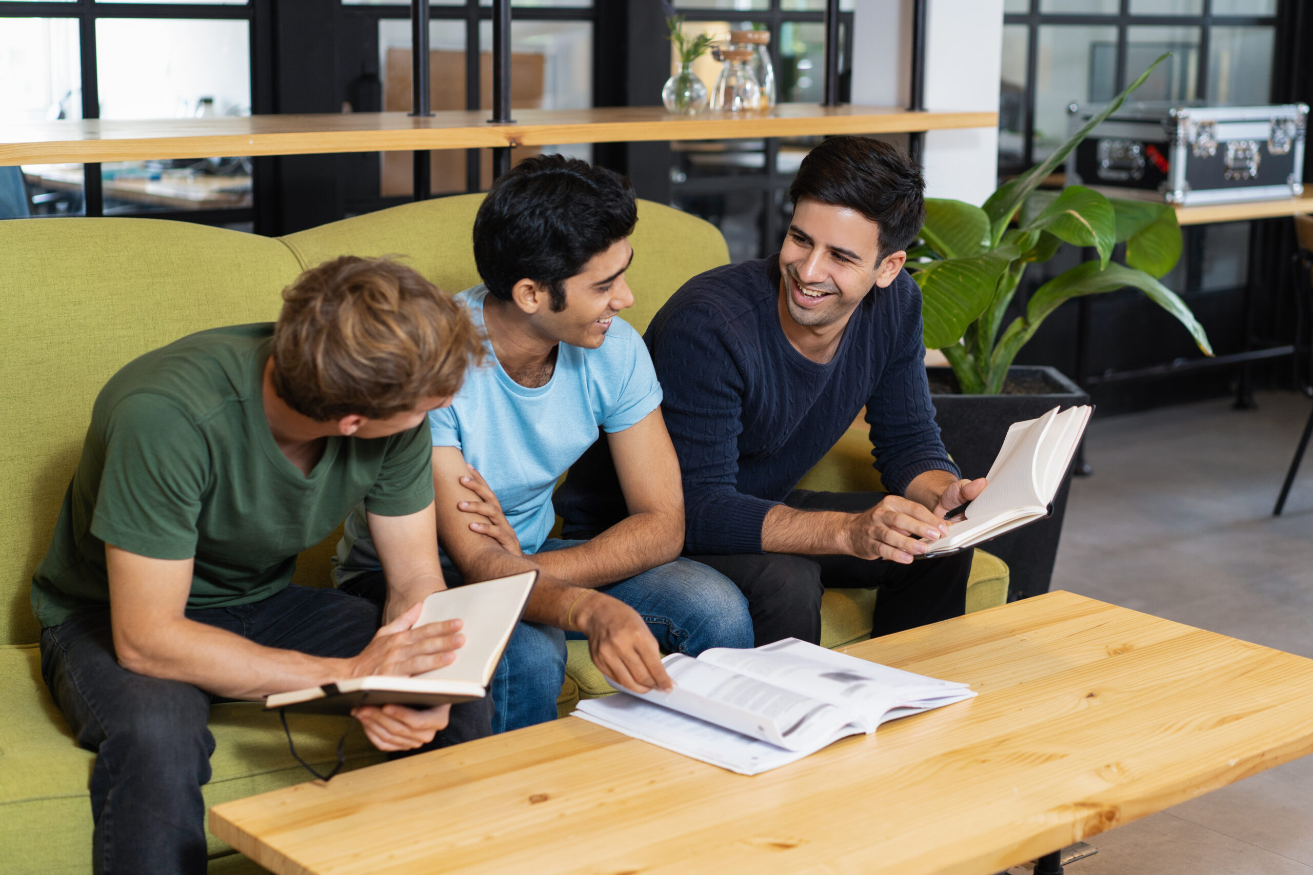 three relaxed fellow students studying and chatting